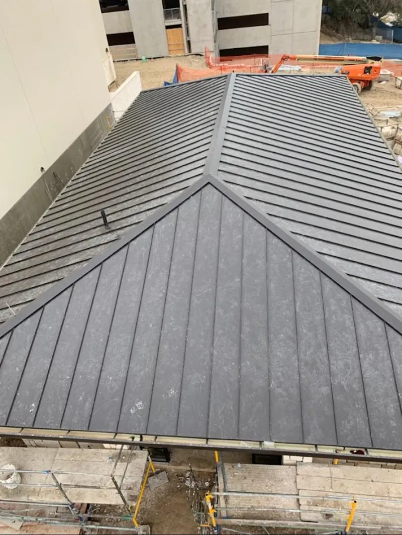 Commercial metal roof construction with crane equipment in Gonzalez